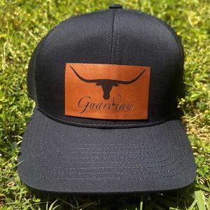 front of black hat with longhorn silhouette and guardian written underneath in script
